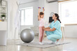 © Pixel-Shot - Female osteopath and little patient with dumbbells doing exercises in clinic