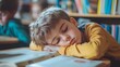 © PaulShlykov - Caucasian bored schoolboy sleepy at school elementary education study learning tired exhausted sad upset fatigued child boy kid pupil schoolchild lying at table desk lesson class relax health problem