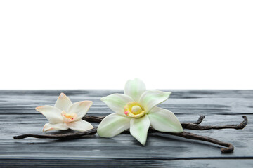 Wall Mural - Aromatic vanilla pods and flowers on table against white background