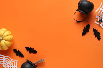 Wall Mural - Black bats with paper spider web, cauldrons and fresh pumpkin for Halloween party on orange background