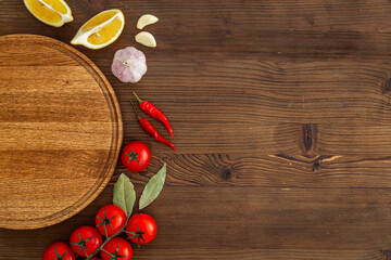 Wall Mural - Wooden cutting board and vegetables with spices, top view. Cooking layout