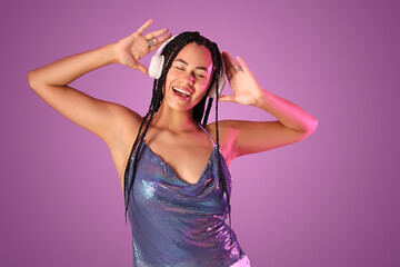 Wall Mural - Beautiful young African-American woman with braids in headphones on purple background