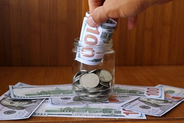 Wall Mural - Man Puting money to glass jar