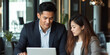 © Rapid Stock - Asian Businessman and business woman working on a IT or financial project on a laptop with a beautiful office background bokeh