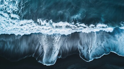 Aerial drone view or top view perspective photography of a beautiful transparent clear sea or ocean waves and foam splashing on the dark navvy blue or gray sand beach