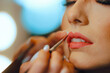 © nicoletaionescu - Detail of Lipstick Applied on a Client by Professional Makeup artist. Perfect red Lip achieved by a professional beauty specialist