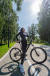 © Михаил Решетников - Caucasian woman riding a bike in a park. Vertical photo.
