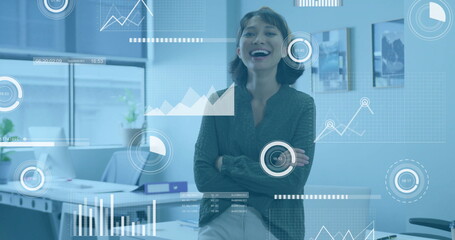 Wall Mural - Businesswoman in office with data analytics and graphs image over workspace