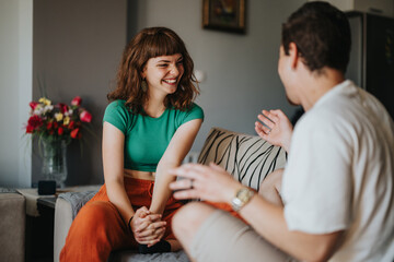 Wall Mural - Two friends engage in a joyful conversation, sharing laughter and friendship in a comfortable home setting, creating a warm and inviting atmosphere.