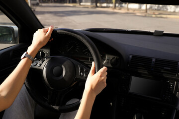 Wall Mural - Woman holding steering wheel while driving car, closeup