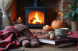 © Creative Catalog - Cozy autumn scene with warm socks, a cup of tea, and pumpkins near a fireplace.