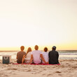 © StarDweller/peopleimages.com - Back, people and relax for picnic at beach with sunset view, social gathering and alcohol basket of holiday break. Friends, rest and reunion together with vacation, bonding and summer travel by ocean