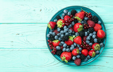 Wall Mural - Mix of ripe colorful berries in bowl photography . Blueberry , strawberry , raspberry , blackberry and red currant . Top view