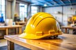 © Gallery BD - Hard plastic helmets, placed on the workbench of the engineering team, are essential for ensuring safety at the worksite. These safety helmets are a critical part of protective gear.