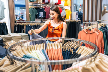 Wall Mural - Asian beautiful young women look product of clothes in shopping mall. 