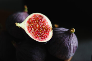 Wall Mural - Close up of fresh ripe fig fruits in a wooden bowl on dark grey table 