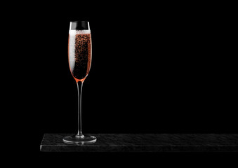 Elegant glass of pink rose champagne with bubbles on blavk marble board on black background. Space for text