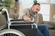© auremar - disabled man tries to move from sofa to wheelchair