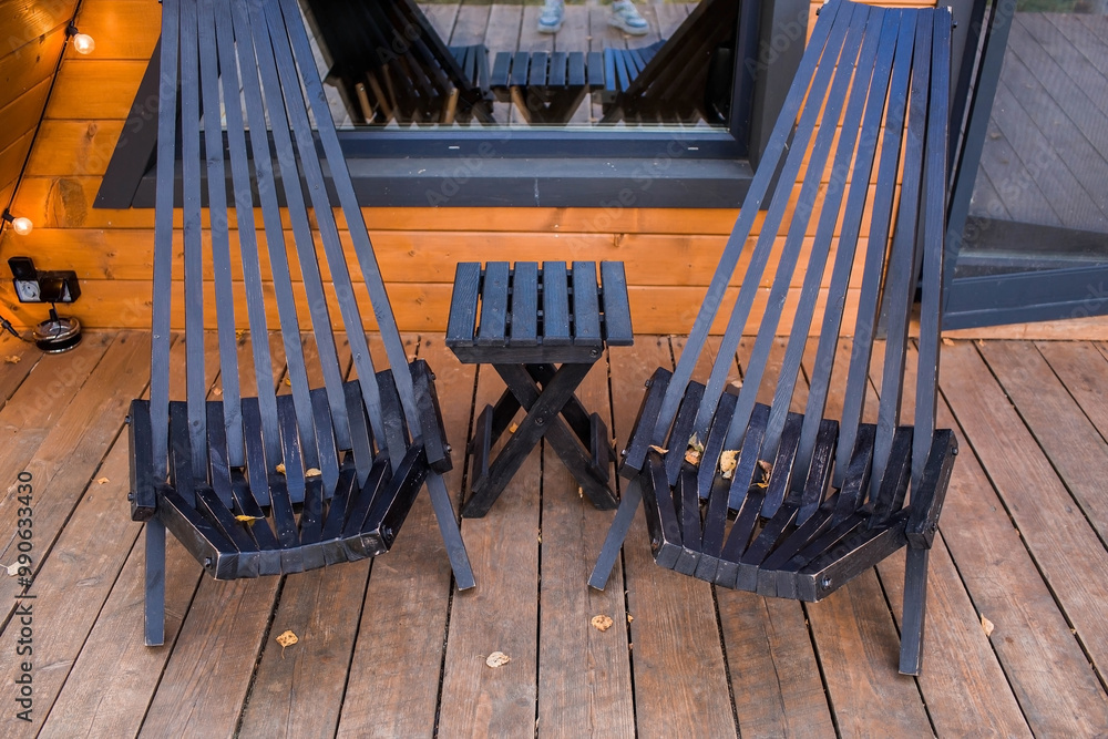 Two stylish wooden deck chairs on the veranda of an A-shaped frame ...