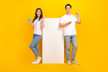 Poster - Full length photo of cheerful excited husband wife dressed t-shirts winning egame device empty space isolated yellow color background