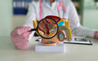 © Nadzeya - Urologist holds magnifying glass over male reproductive system model