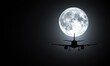 © Autaporn - Airplane silhouette flying in front of a large full moon, dark sky background.