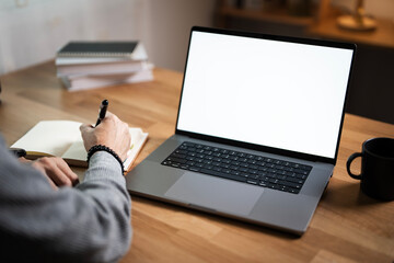 man working with planning project, using laptop blank screen mockup, sitting at home office.
