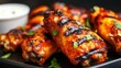 © Piyapat - Delicious grilled chicken wings with barbecue sauce and fresh herbs on a dark plate, perfect for appetizers and gatherings.