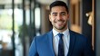 © andyaziz6 - A portrait of a handsome, young businessman in a suit and tie smiling confidently.