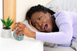 © Prostock-studio - Bad Morning. Black Girl Turning Off Alarm-Clock Touching Head Having A Hard Time Waking Up Lying In Bed Indoor. Panorama