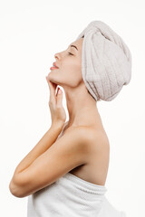 Wall Mural - A woman with flawless skin wearing a hair towel after a spa treatment. Her relaxed expression evokes a sense of harmony and self-care against a white background.