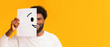 © Prostock-studio - Putting smiling face on. Black cheerful guy holding paper with smiley face printed on, happiness and joy concept
