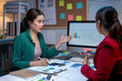 © Wasana - Two businesswomen having meeting analyzing financial chart using computer