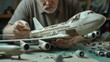 © Narongrit - Model Maker Assembling Tiny Pieces of Airplane Model