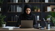 © Ilja - Focused Muslim Businesswoman in Hijab Working on Laptop at Office Desk, Modern Workspace