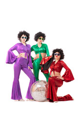 Three female pop stars in neon clothes pose in front of a silver ball. The women wear colorful clothes and eighties-style sunglasses.