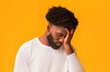© Prostock-studio - Upset black man covering face with hand, disappointed or stressed, orange studio background, copy space