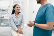 © InsideCreativeHouse - A young male doctor radiologist consults talks to a female patient young woman in a modern medical private clinic before X-ray computed tomography procedure. Healthcare and medicine