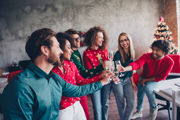 Wall Mural - Photo of cheerful young people colleagues toast drink champagne cozy christmas party decor spacious office indoors