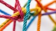 © B 7 YOU - Close-up of a knot of colorful string against a white background.