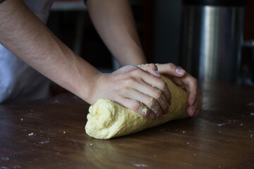 Photograph of baker's hands kneading on a table.