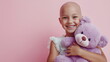 © W.O.W - Little smiling girl with purple teddy bear on pink background. Cancer treatment healing. World day against cancer, lupus