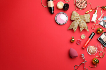 Wall Mural - Flat lay composition with makeup products and Christmas decor on red background. Space for text