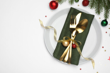 Poster - Christmas table setting with plate, cutlery, napkin and festive decor on white background, flat lay. Space for text