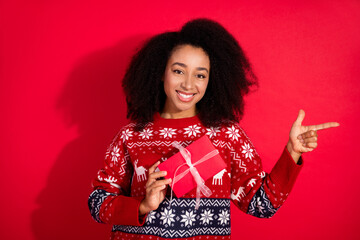 Canvas Print - Photo of adorable lovely girl wear ugly ornament sweater getting noel xmas gift pointing empty space isolated red color background