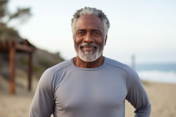 Wall Mural - Portrait of a happy afro-american man in his 60s sporting a long-sleeved thermal undershirt in sandy beach background