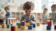 © JAYDA RIN - A cute boy playing with colorful blocks in a well-lit daycare classroom   daycare, early learning