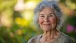 © MakoPoko - Close-up portrait of a smiling elderly woman with flowing grey hair against a soft natural backdrop emphasizing wisdom and serenity