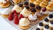 © arthit - A delightful spread of assorted dessert pastries, including clairs, tarts, and cream puffs, arranged on a clean white plate.