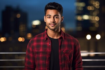 Canvas Print - Portrait of a tender indian man in his 20s wearing a comfy flannel shirt over modern cityscape background